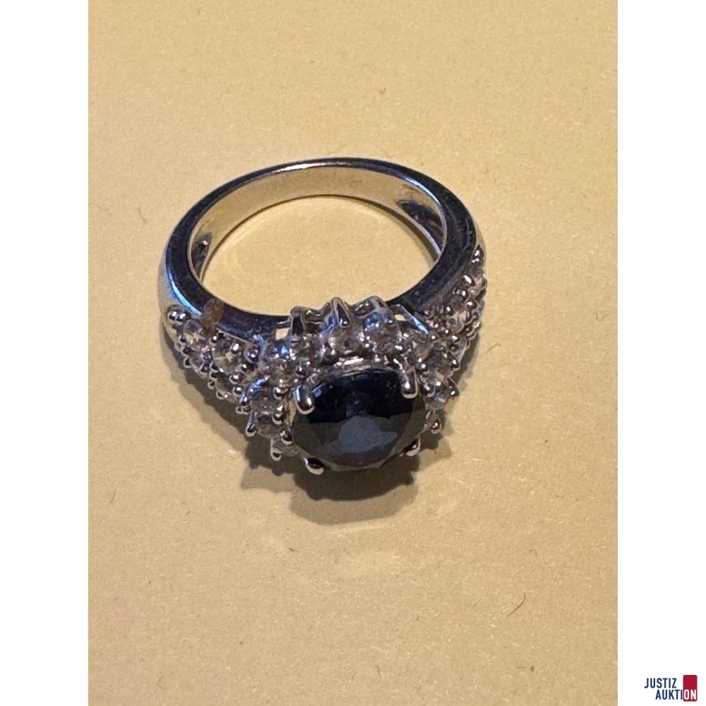 Silberfarbener Ring mit kleinen wei&szlig;en und gro&szlig;em blauen Stein