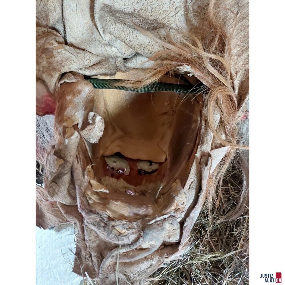 2 Perchtenmasken mit einem schwarzen Fell und Stock mit Geisfuß